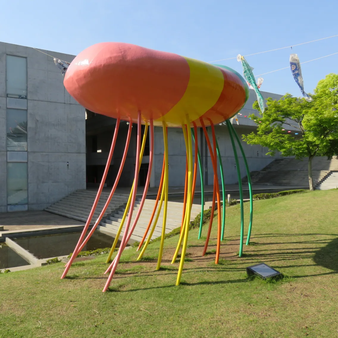 芝生の上に立つ、たこのような形をしたカラフルな彫刻