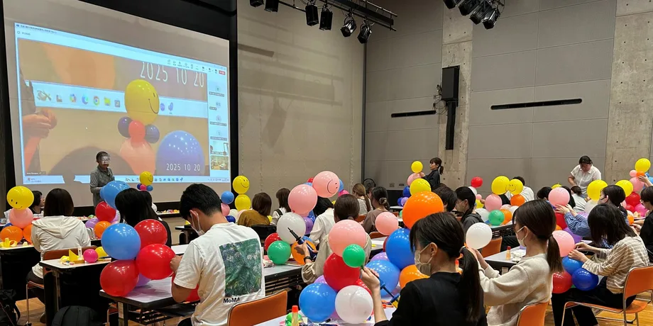 客席いっぱいの子どもたちが、スクリーンに映った映像を見ている研修のようす